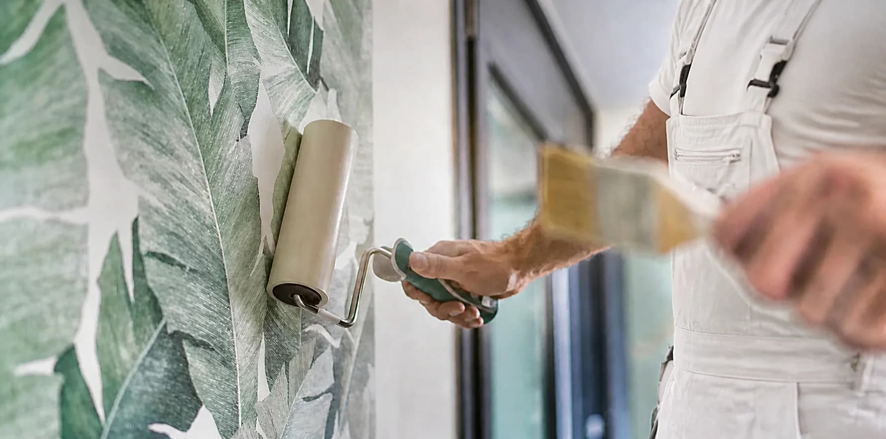 Professionelle Tapezierarbeiten, Maler bringt Vliestapete an Wohnzimmerwand an